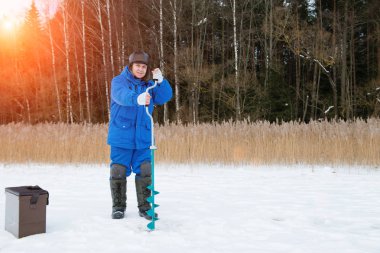 Yaşlı adam soğuk kış güneşli gün gölde balık tutma