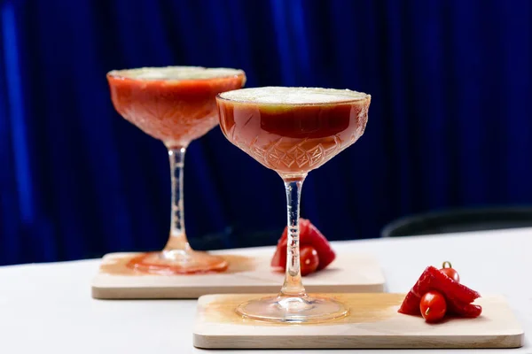 Dois cocktaisl alcoólico vermelho em copos de martini no fundo azul — Fotografia de Stock