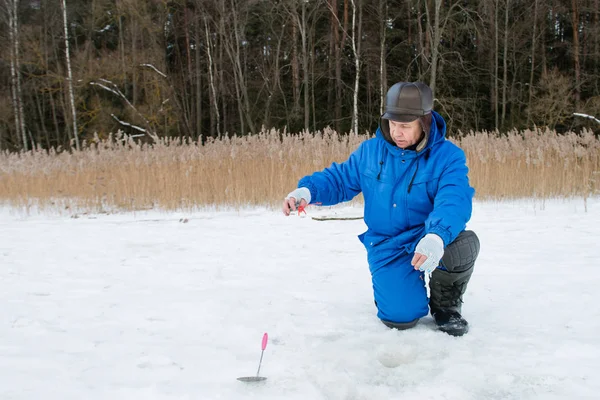 Velho homem de pesca no lago no dia frio de inverno — Fotografia de Stock