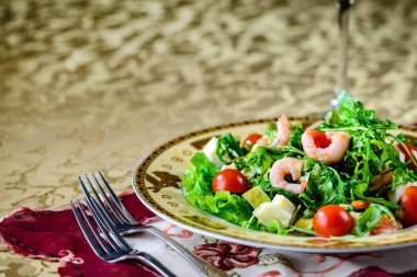 Salata karides, marul yaprakları ve domates bir plaka ile bir 