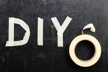DIY kelimenin üstten görünüm koyu arka plan üzerinde yapışkan bant ile yapılan,