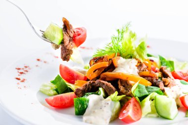 Kızarmış biftek salata domates, salatalık, fet yeme işlemi