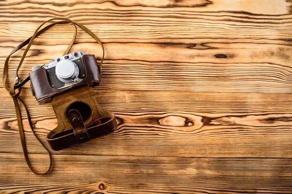 Staré retro vinobraní staromódní fotoaparát v koženém pouzdře na dřevěné — Stock fotografie