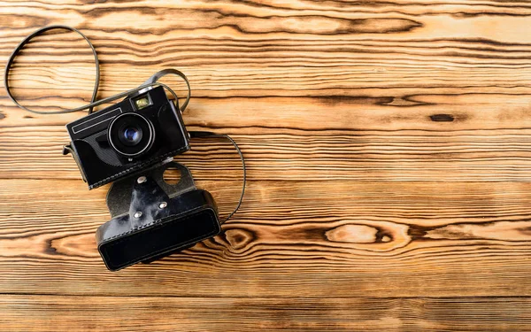 Oude retro vintage ouderwetse camera in leergeval op houten — Stockfoto