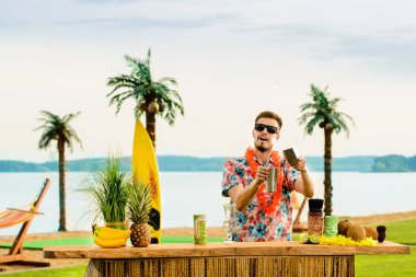 Barın yakınında duran yakışıklı barmen sayaç ve c hazırlanıyor