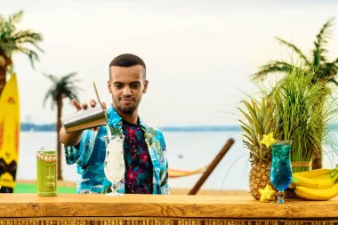 Barın yakınında duran yakışıklı barmen sayaç, horoz hazırlanıyor