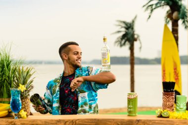 Barın yakınında duran yakışıklı gülümseyen Latin Amerika barmen 