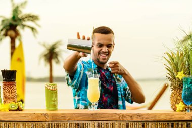 Barın yakınında duran yakışıklı gülümseyen Latin Amerika barmen 