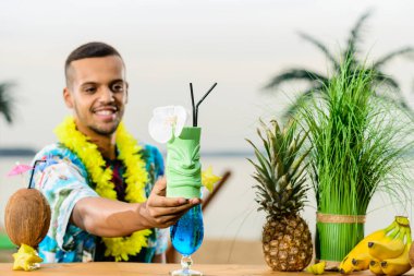 Barın yakınında duran yakışıklı gülümseyen Latin Amerika barmen 