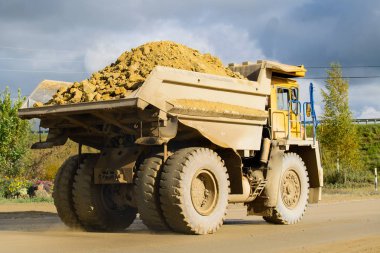 Mineral çıkarımı. Mat taşıyan büyük sarı maden kamyonu