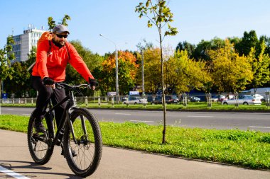 Şehirde bisiklet sokak sürmek sırt çantası olan yetişkin adam. Araba