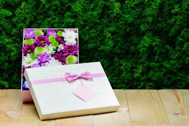 Pembe hediye kutusu ahşap tahta tekrar üzerinde güzel taze çiçekler