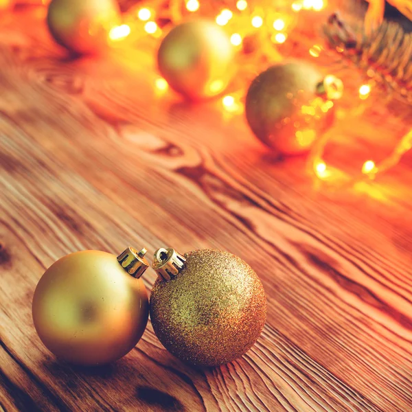 Christmas background with toy balls and glowing lights on wooden