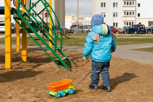 Criança com um brinquedo na caixa de areia — Fotografia de Stock