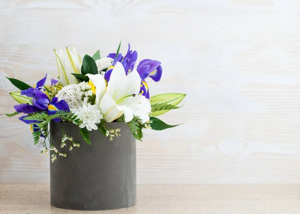 Floral arrangement of fresh flowers on a wooden background with