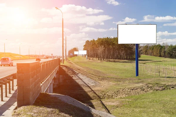 Valla publicitaria en blanco cerca de la carretera con los rayos del sol, simulacro, Copiar espacio —  Fotos de Stock