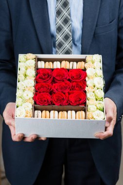 çiçekler ve macaroons içinde kutusu eller mans