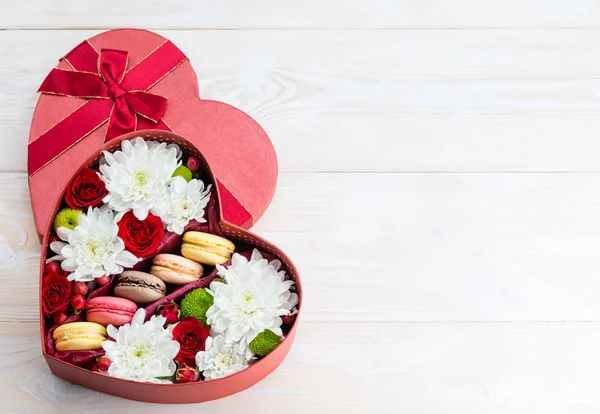 Caja de flores y macarrones corazón sobre una mesa de madera. Copiar espacio — Foto de Stock