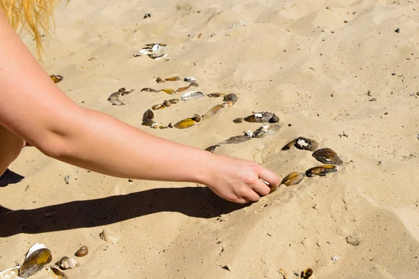 Жіноча рука збирає слово 2017 року на піску мушлі — стокове фото