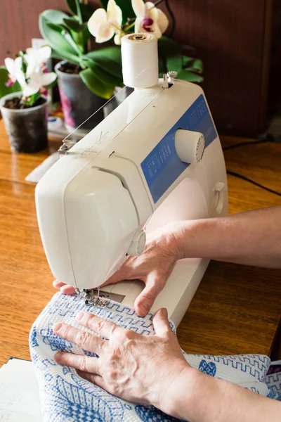 Kadın dikiş makinesine dikiş dikiyor. — Stok fotoğraf