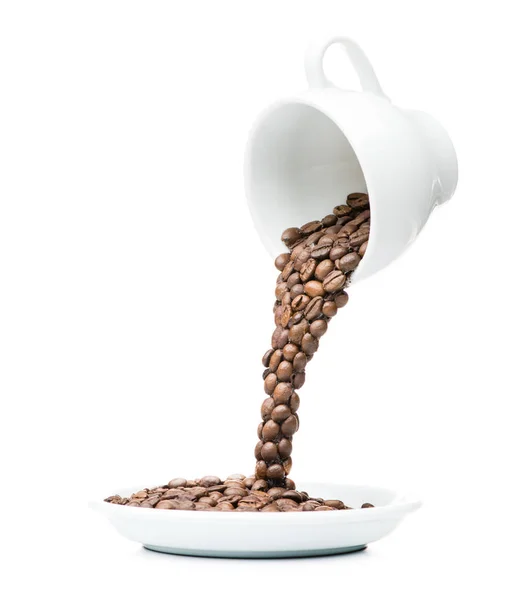 Kaffeebohnen werden aus einer Tasse in eine Untertasse gegossen, Konzept — Stockfoto