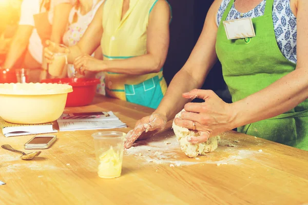 Mani di donna impastando la pasta per pizza su tavolo di legno, processo di — Foto Stock