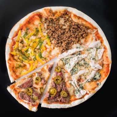 Et pizza plaka, koyu arka plan üzerine dilimlenmiş.