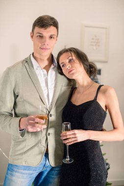 Güzel genç çift bardak şampanya ve smili tutuyor