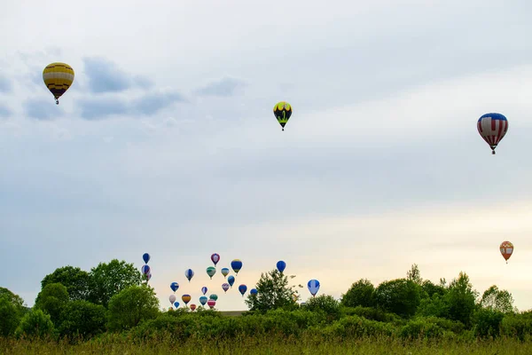 Πολύχρωμα αερόστατα που πετούν πάνω από το πεδίο και την λίμνη στο summ — Φωτογραφία Αρχείου