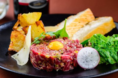 Ham lezzetli biftek tartare ile yumurta sarısı ve tost plaka üzerinde 