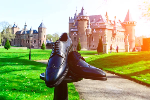 Acessório de cerimónia de casamento. Sapatos de noivo preto perto do castelo ou — Fotografia de Stock