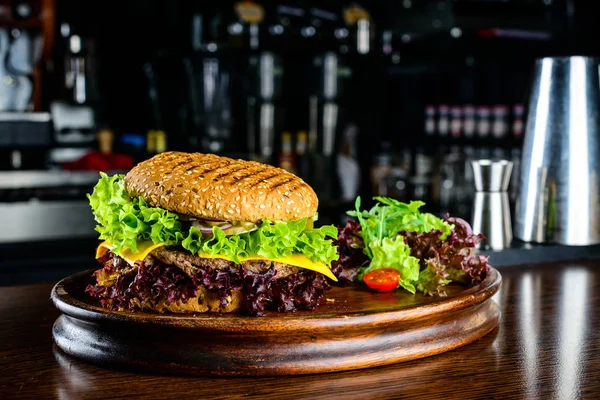 Hambúrguer saboroso com bife, queijo, salada e cebola no wo — Fotografia de Stock