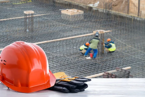 Casco de construcción naranja en el fondo de la construcción de edificios —  Fotos de Stock