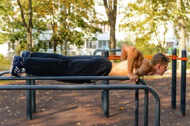 İtme yapıyor atletik beyaz delikanlı ups üzerinde paralel bar