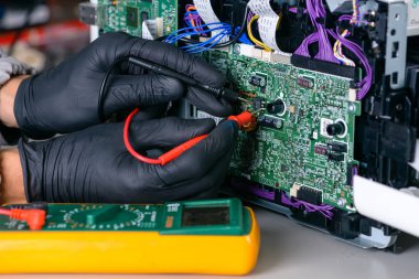 Master hasar için bir multimetre kullanarak onarım Ofis donatım arıyor.