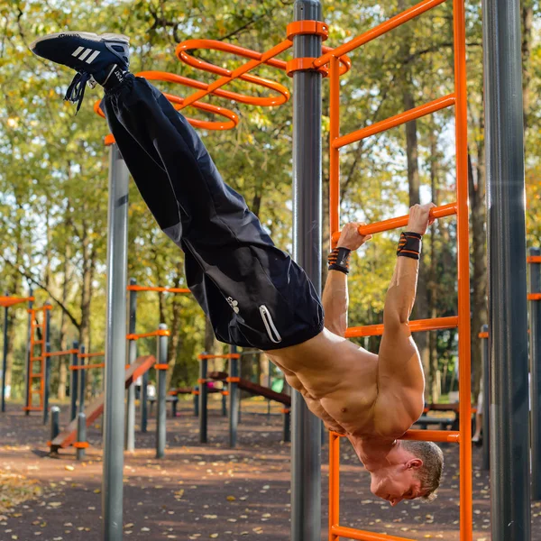 Atletische man of man met gespierd lichaam opleiding op stadion buiten. zomer-activiteit en sport. gezonde levensstijl — Stockfoto