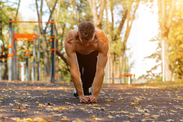 Sports man on the street Playground engaged in sports and push-UPS from the floor. Sports and healthy lifestyle.