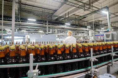 Fabrika işçisi konveyör bira içecek şişe ile çalışma