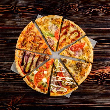 Farklı dilim pizza ahşap arka plan üzerinde yuvarlak bir pizza şeklinde ortaya koydu