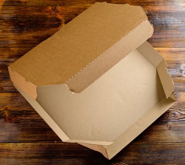 empty delivery cardboard box for pizza open lid on wooden table