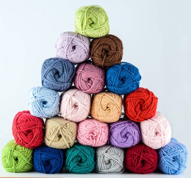 Beyaz arkaplan piramidinin üzerinde renkli iplik yumakları