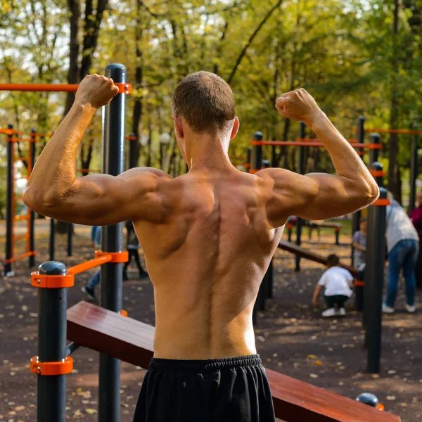 Musculoso atlético fitness chico en una calle parque infantil en el entrenamiento — Foto de Stock