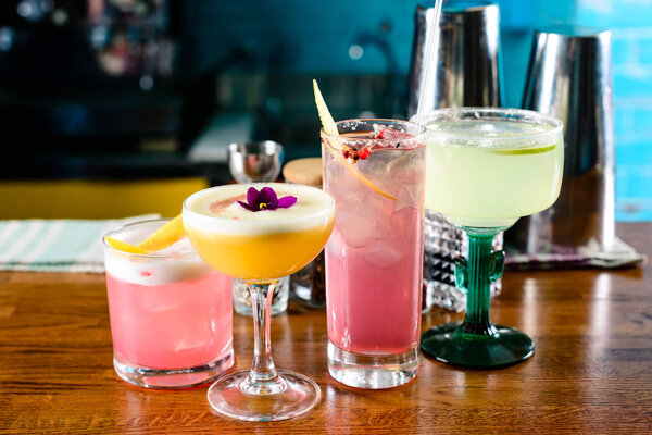 row of various colourfull alcoholic cocktails on bar counter in pup or restaurant copy space