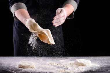 Şefin elleri ahşap arka planda hamur pişiriyor. Yemek konsepti. Pizza yapan adam.