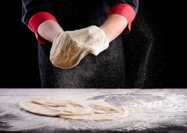 Şefin elleri ahşap arka planda hamur pişiriyor. Yemek konsepti. Pizza yapan adam.