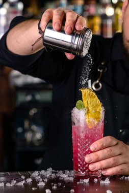 Barda kokteyl hazırlayan barmen, alkol içkileri, insanlar ve lüks konsept, bir barda kokteyl süsleyen barmen.
