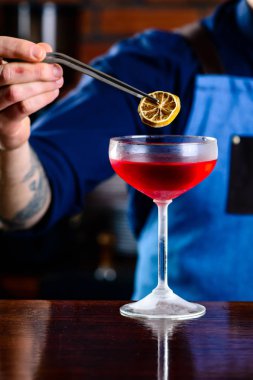 Barda kokteyl hazırlayan barmen, alkol içkileri, insanlar ve lüks konsept, bir barda kokteyl süsleyen barmen.