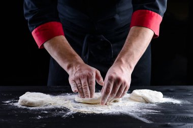 Şefin elleri ahşap arka planda hamur pişiriyor. Yemek konsepti. Pizza yapan adam.