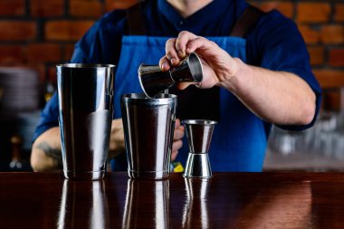 Barmen alkollü kokteyl hazırlığını bitirir. Barda kokteyl yapan uzman barmene yakın plan.