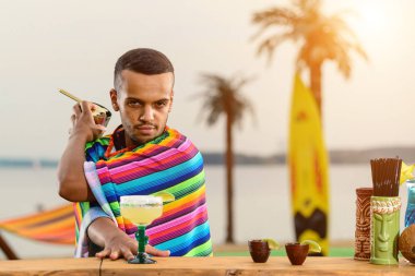 Plaj barında barmenlik yapmış.